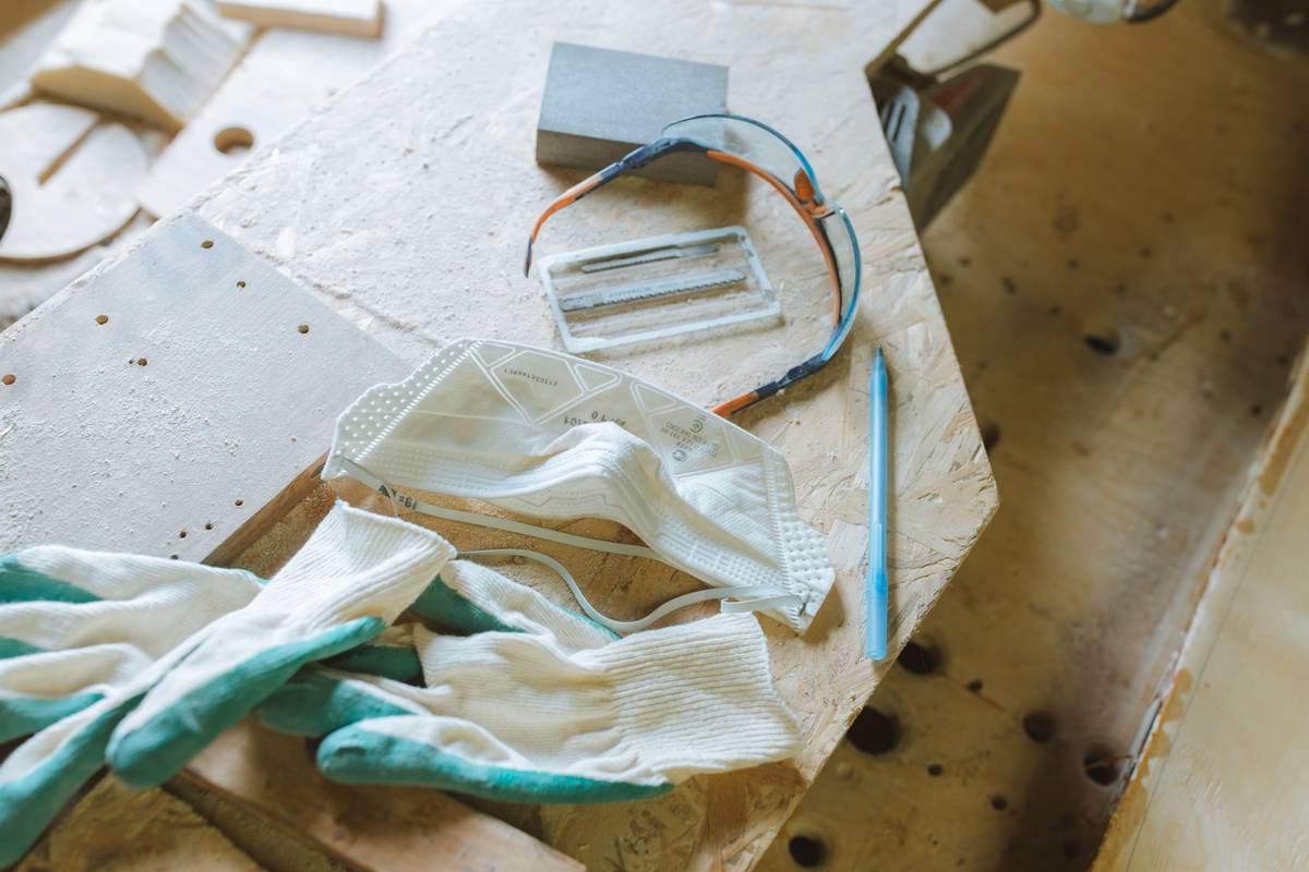 Beginner's workbench setup showing core supplies needed for woodworking including hand saw, chisels, measuring tape, and clamps
