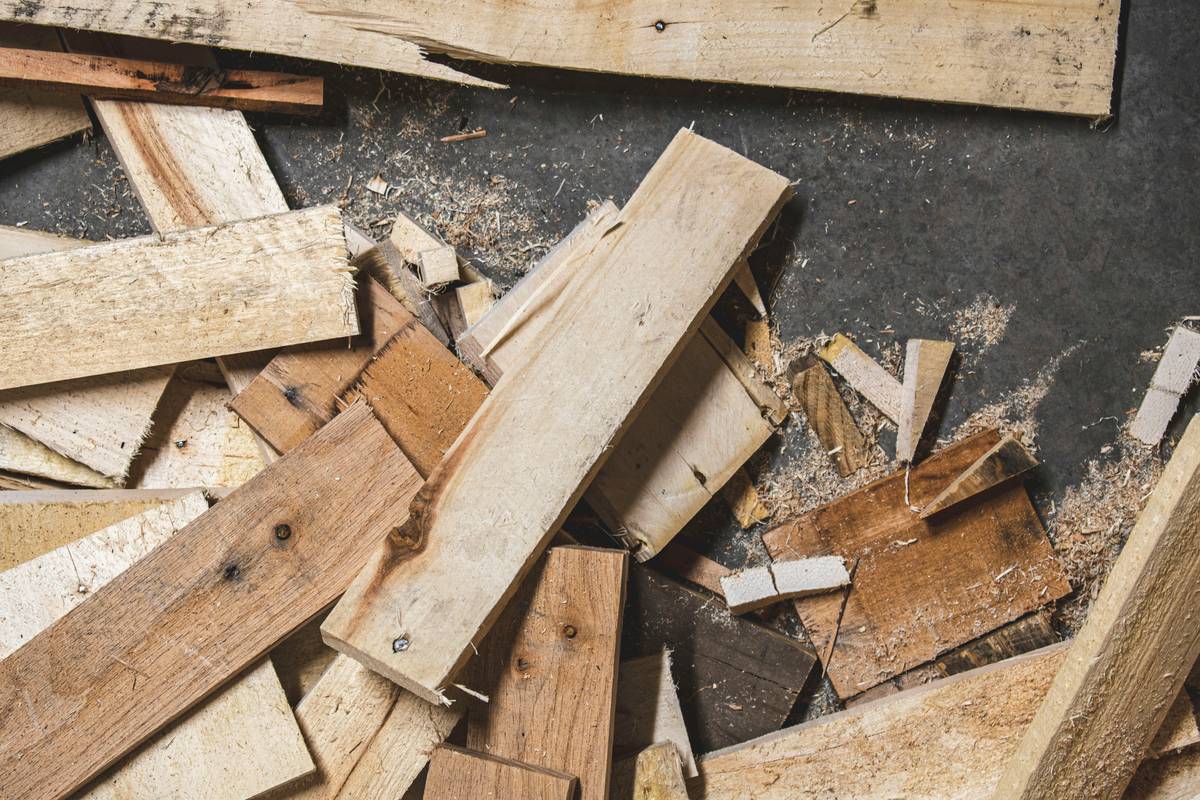 Comparison of high-quality kiln-dried lumber versus warped big-box store wood showing why supplies needed for woodworking include good raw material