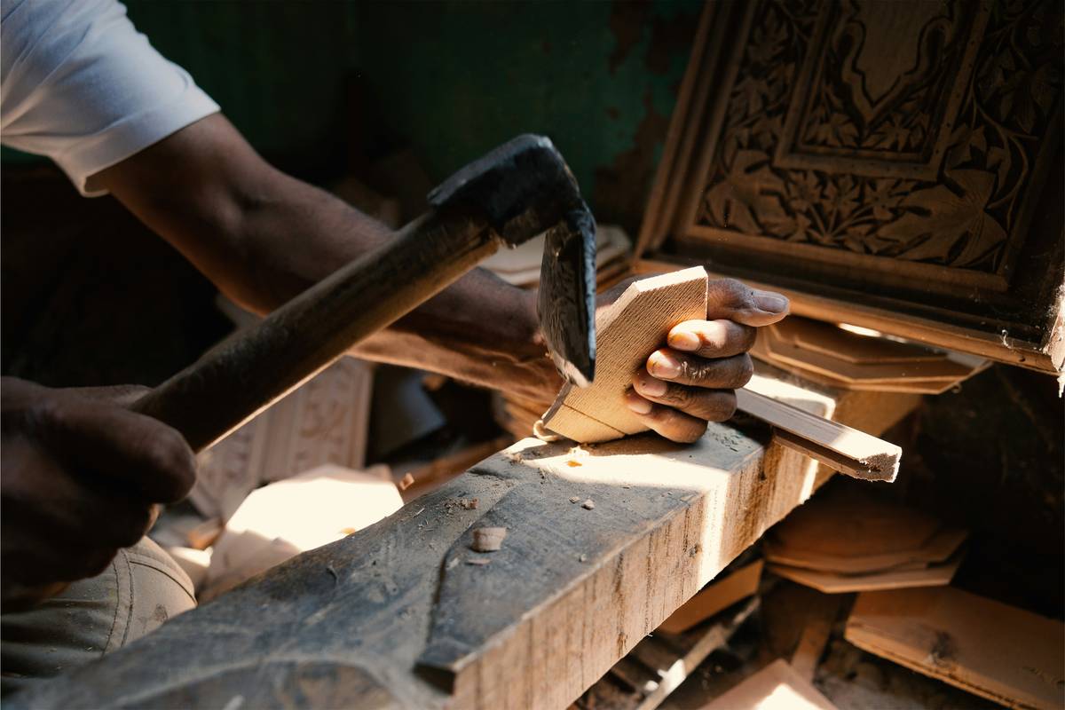 woodwork projects for beginners showing a beginner sanding a simple wooden shelf